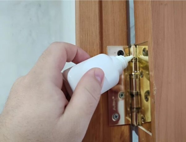 Nhỏ dầu bôi trơn lên khớp bản lề cửa